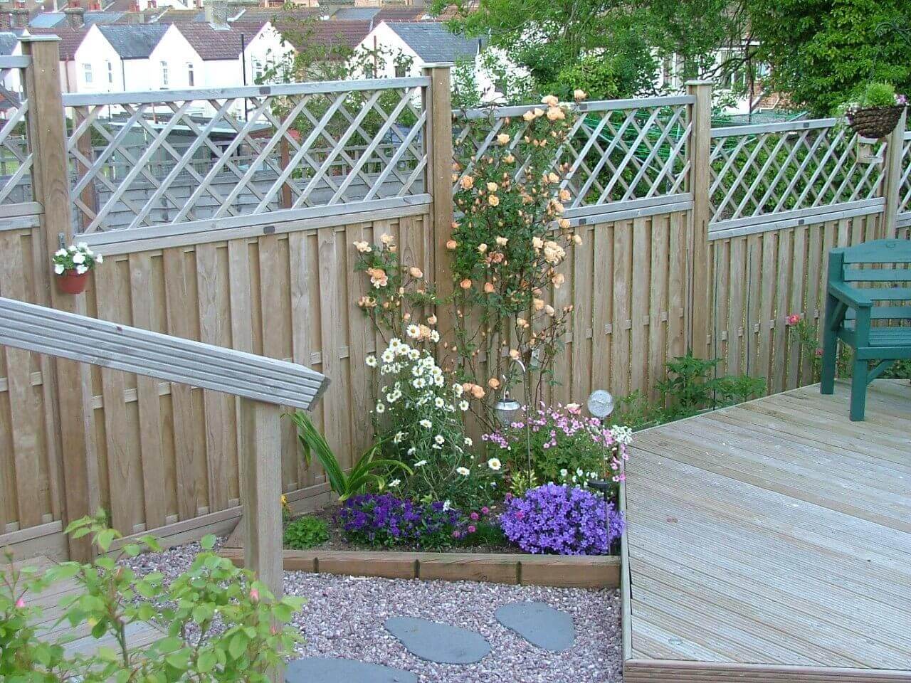 Rose flower bed from landscape timbers and matching fence