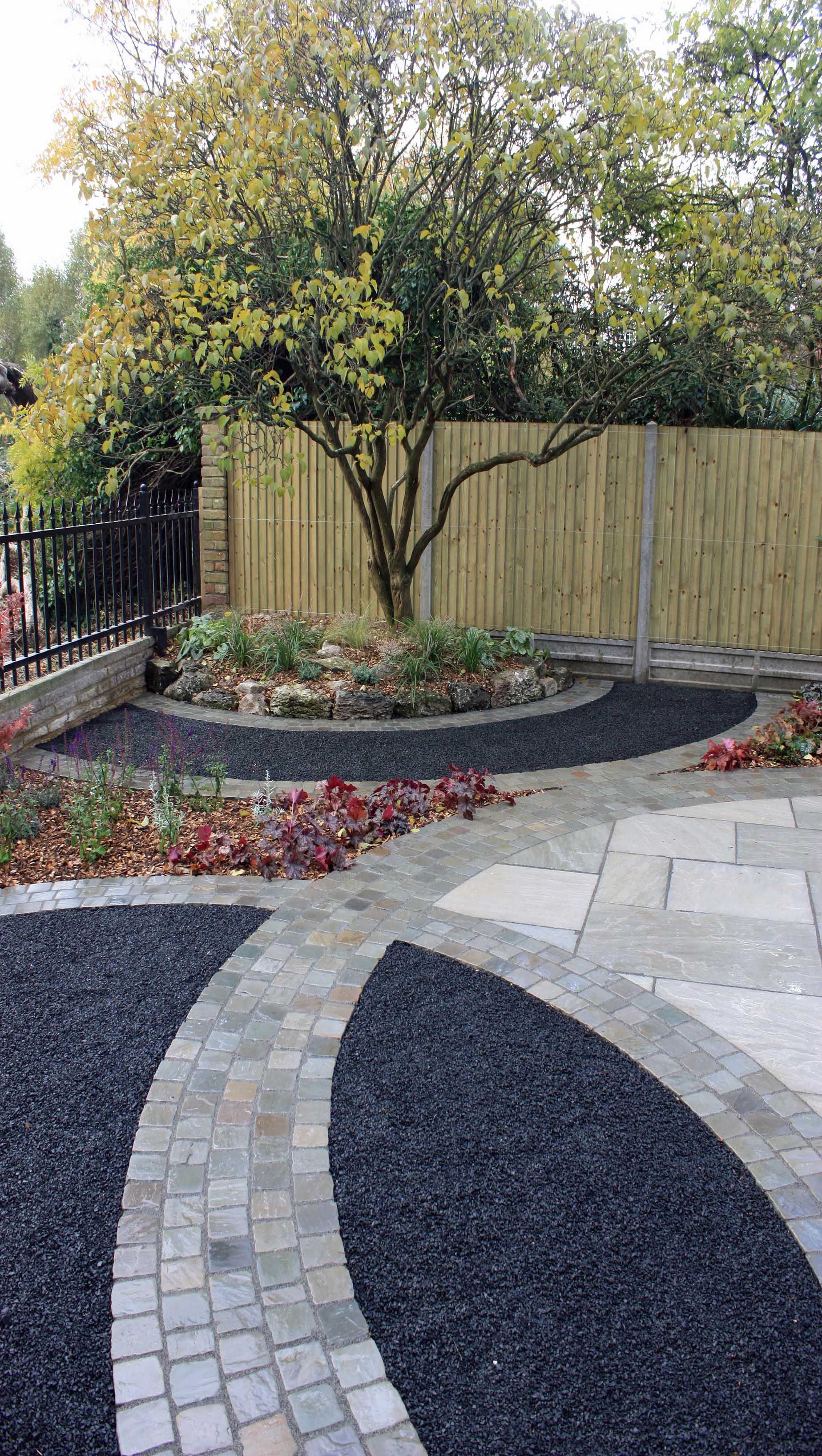 basalt paving with featherboard fencing