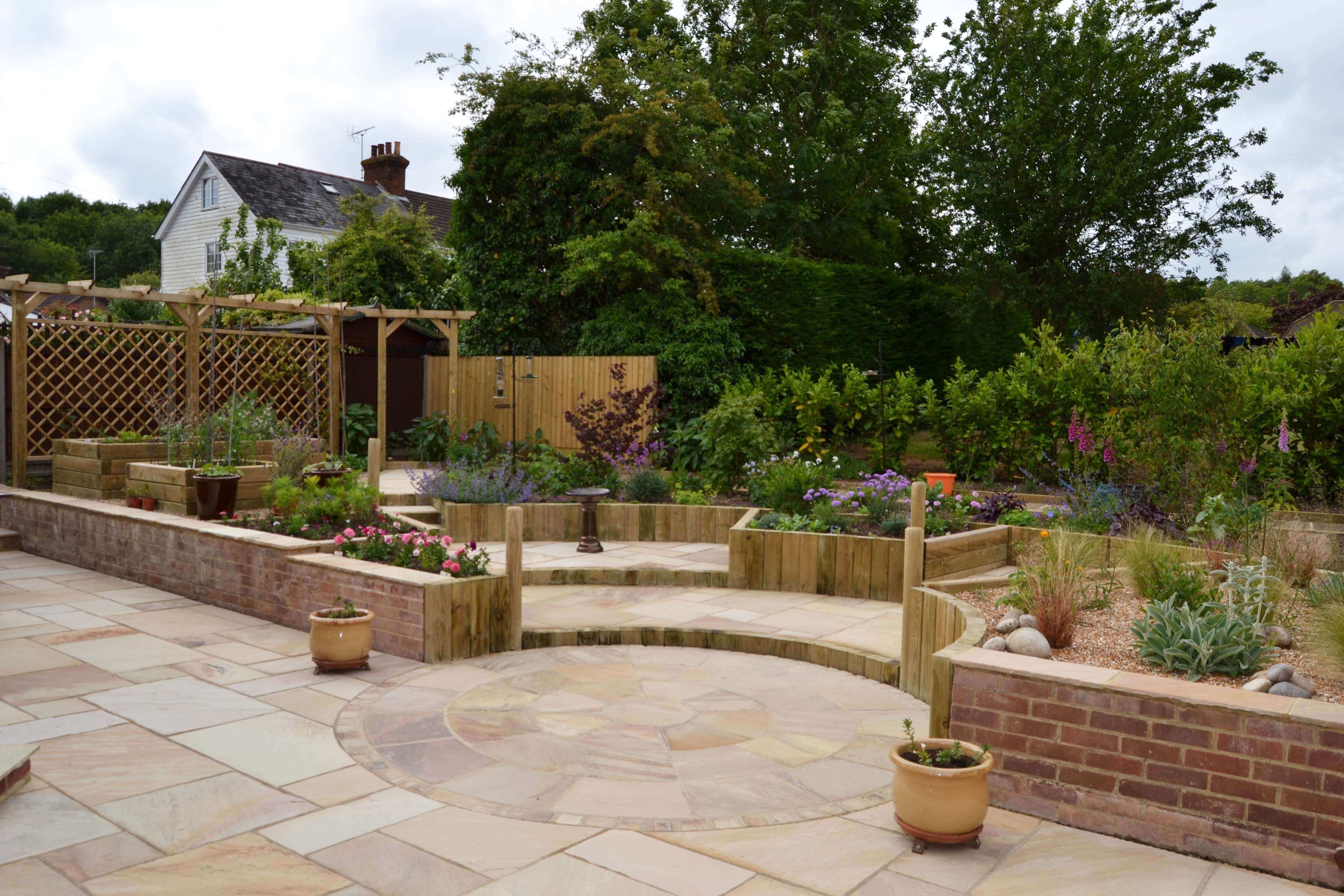 paving raised beds with single wooden pergola