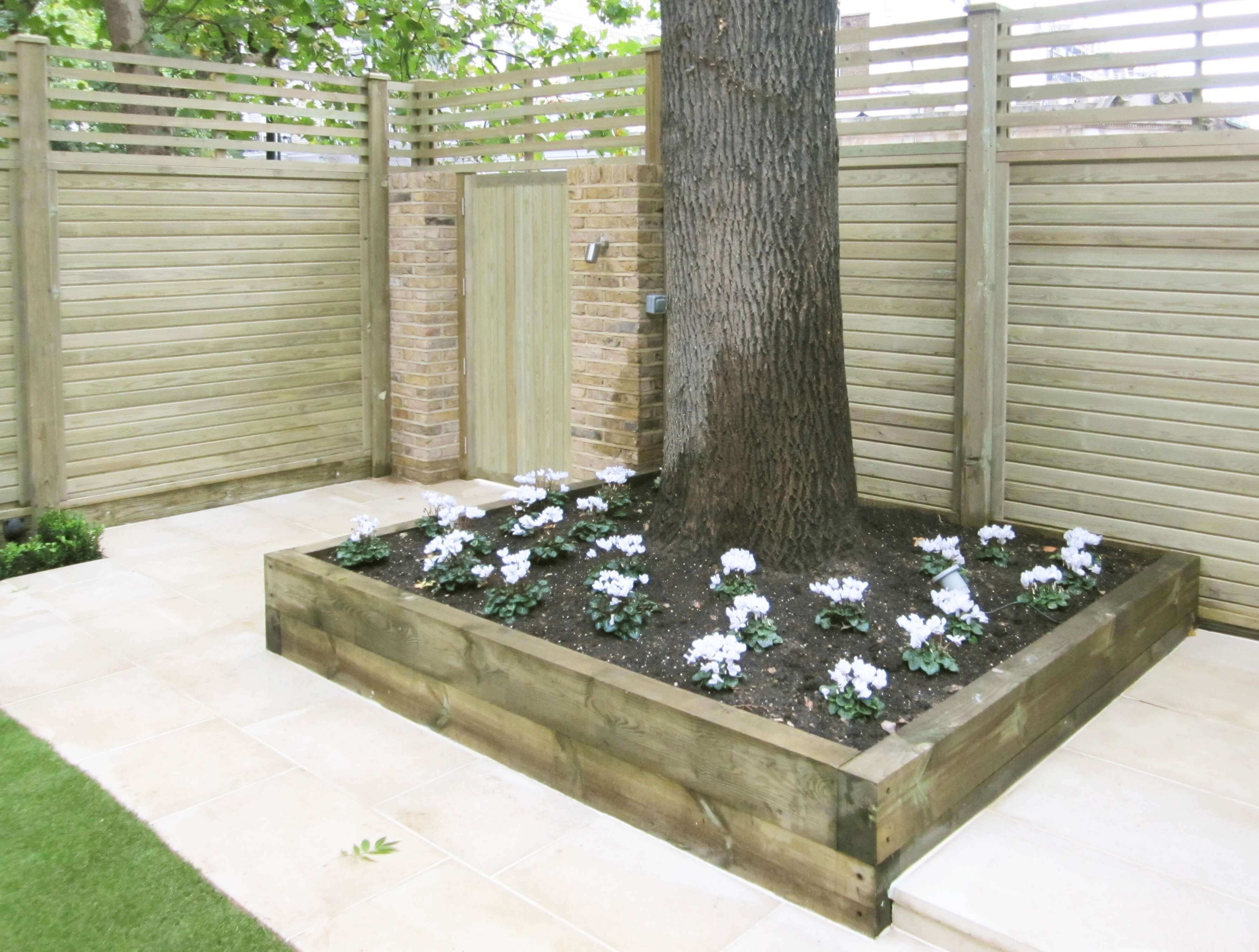 New panels and garden gate with raised bed around tree