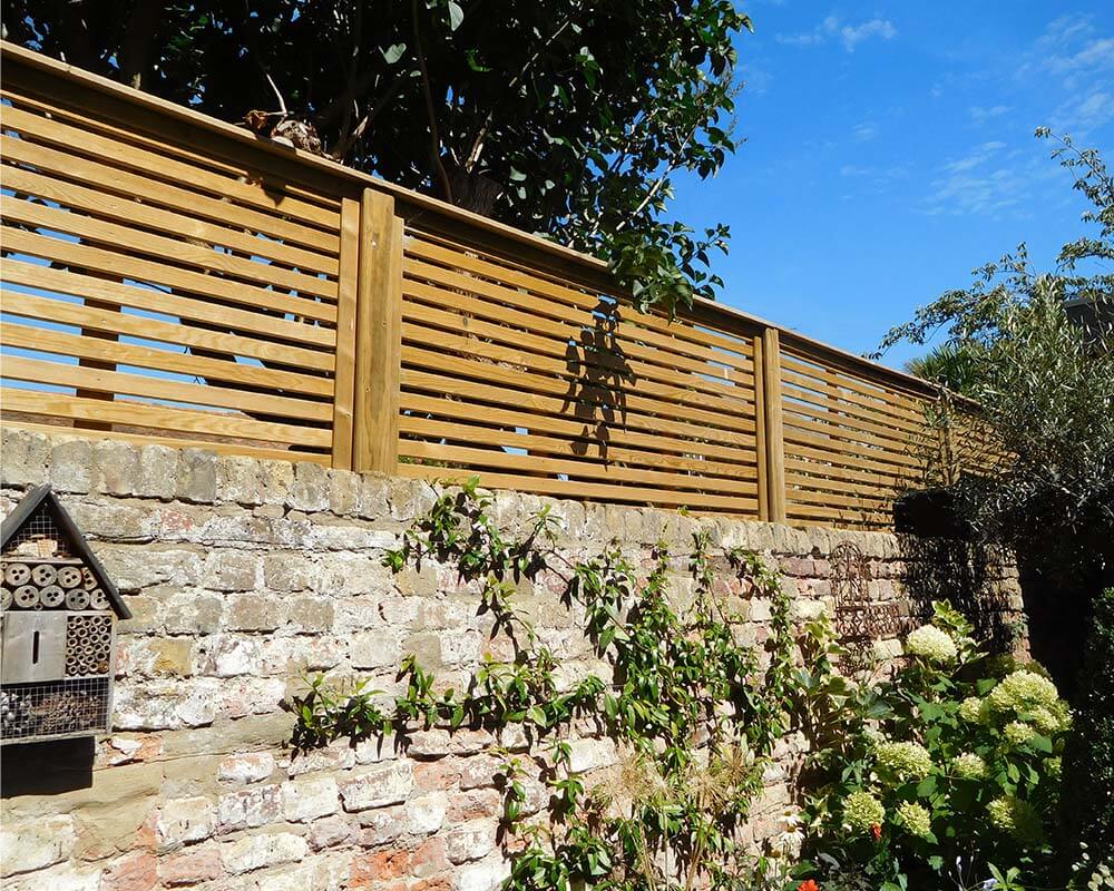 venetian fencing installed on top of wall